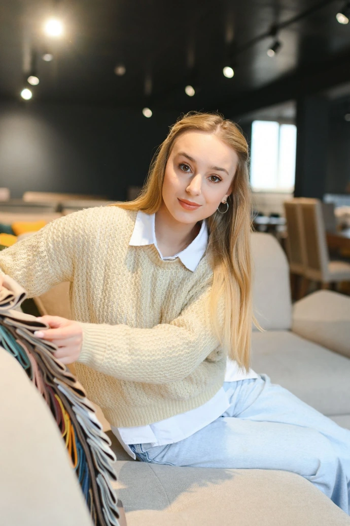 Woman designer at furniture store looking at textile swatch