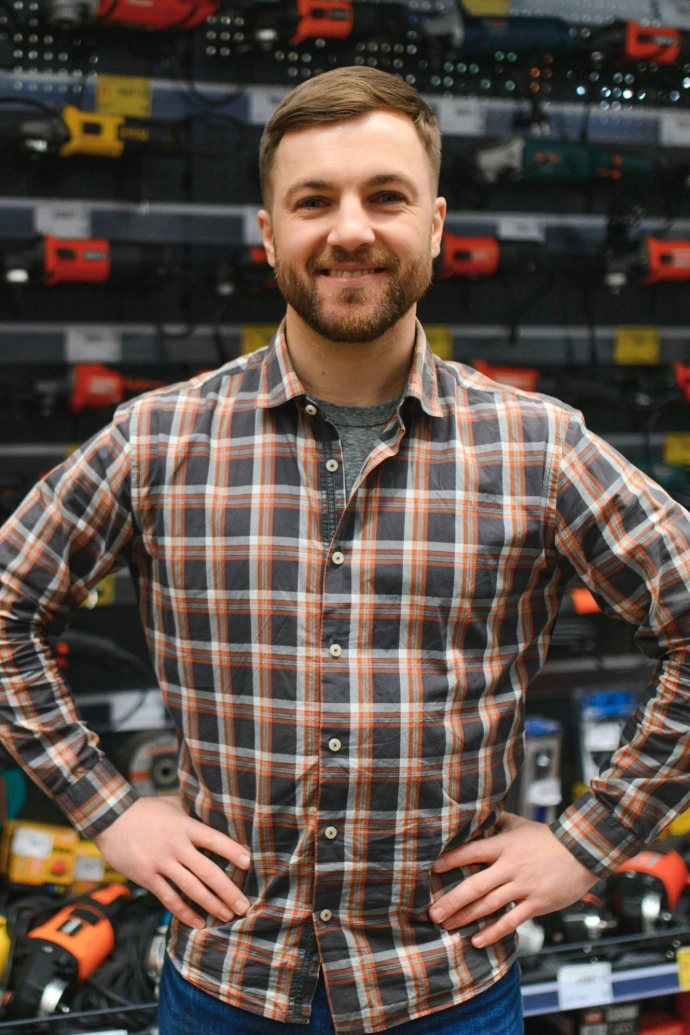 Mature man worker posing in hardware store aisle